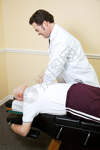 脊椎科医生在检查桌上调整了一位老年人的脊椎图片