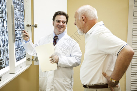 医生或按摩师向他背部疼痛低的病人解释脊椎CT扫描结果图片
