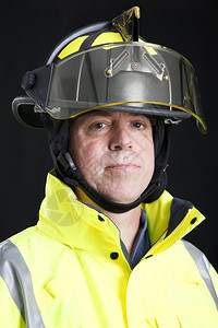 一个严肃的消防员头部和肩膀肖像演播室用黑色背景拍的图片