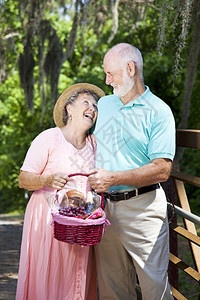 老夫妇带着野餐篮子一起笑图片