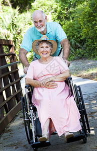 老人用轮椅将残疾妻子推过公园图片