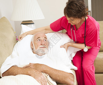 家庭保健护士在一位年长病人的枕头上吹嘘图片