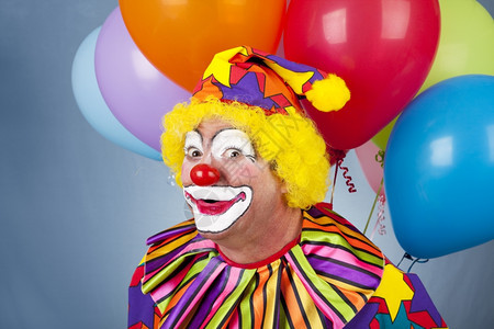 有趣的生日小丑带着一堆气球背景图片