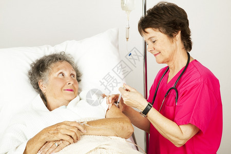 医院护士在一位老年女病人的手臂上注射针剂图片