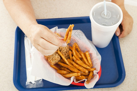 一盘油炸快餐顾客拿着一罐油炸薯条放在手和煎饼上图片