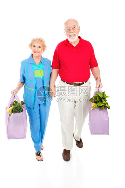 有环保意识的老年夫妇用可重复使的袋子把食品带回家图片