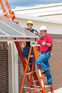 两名工人安装了太阳能电池板并给拇指举起标志图片