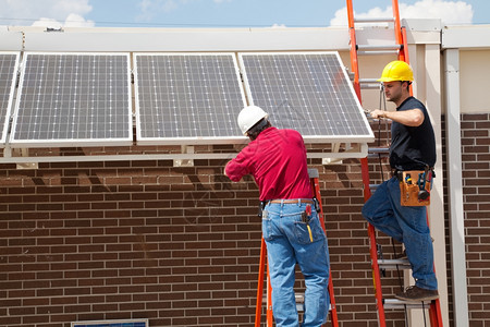 两个电工在一栋大楼上安装太阳能电池板图片