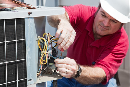 空调修理工重新装设压缩机专心操作人的手和电线图片