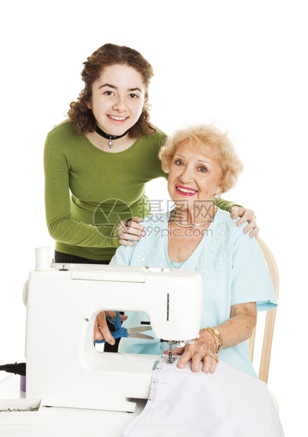 少女和她祖母一起在缝纫项目上工作孤立的白种人图片