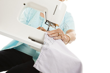 她用缝纫机的时候紧地贴了一位年长女手背景图片
