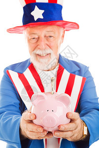 Sam大叔手上有20美元钞票的小猪银行他握着一家小猪银行紧握住他的手专注在猪身上图片