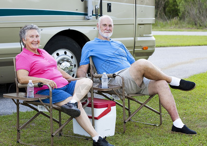 老年夫妇在度假放松他们的汽车家外面图片