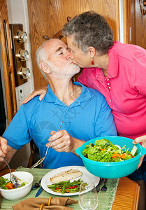 年长者亲吻妻子当她为他做晚饭在们的汽车家图片