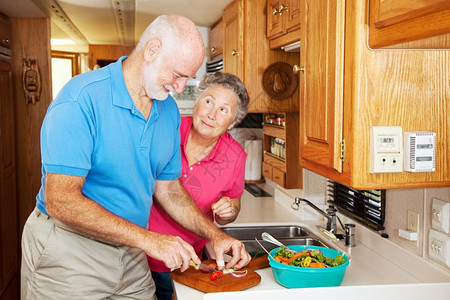 老年妇女感谢她丈夫在房车厨帮助准备晚餐图片