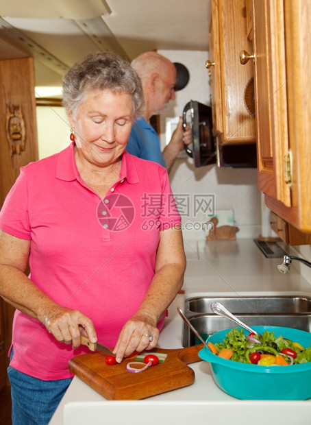 退休的老年夫妇一起在他们的车房厨做饭图片