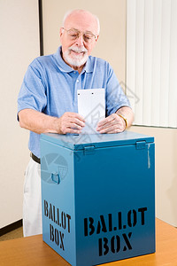 英俊的年长男子在民调中投票图片