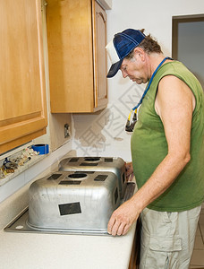 承包商准备把厨房水槽安装在压层柜顶上图片