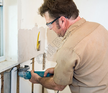 电工使用研磨机切割墙上的隔热层按照行业守则和安全标准真实和确地描述内容图片