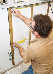 在内部墙上安装电线的工按照行业守则和安全标准真实确地描述内容图片