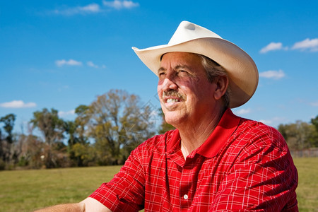 一个成熟牛仔的肖像在他牧场上展望未来图片