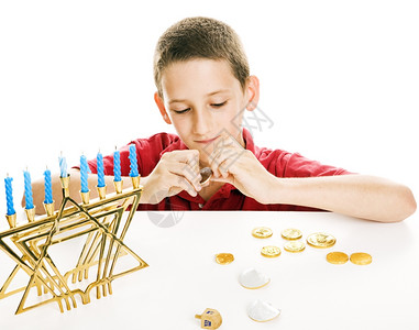 小男孩玩他的德瑞迪尔和吃巧克力硬币在Chanukah白色背景图片
