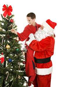 圣诞老人举起可爱的小男孩从圣诞树上摘根糖果杖白色背景图片