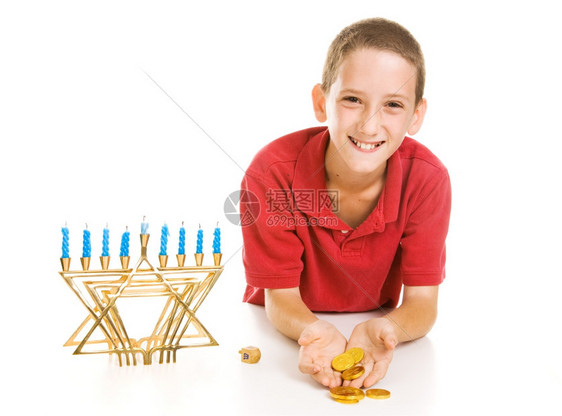 快乐的小男孩拿着Hanukkahelt他赢得了Dreidel比赛图片