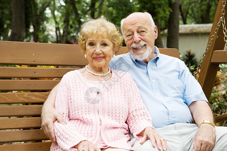 快乐有吸引力的老年夫妇一起放松在公园的秋千图片