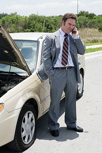 一名持轮胎的商人在路上他打电话给下一个预约说他会迟到图片