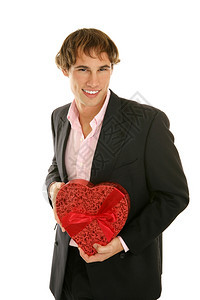 英俊的年轻人拿着一盒心形的情人节糖果孤立在白色上图片