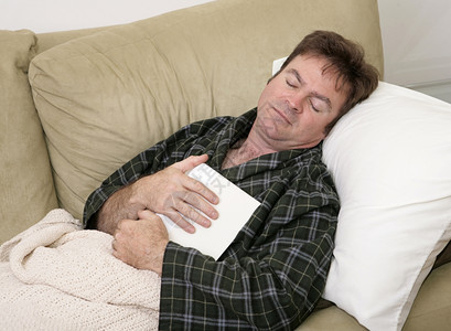 在家工作生病的男子在读书时睡着了图片