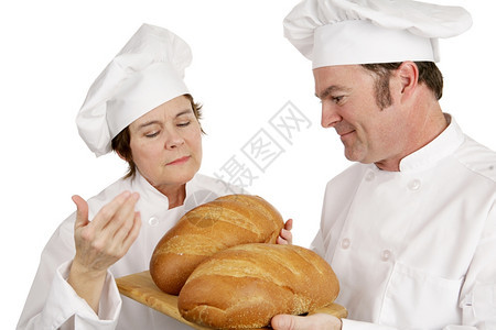 评估学生面包的成熟女厨师孤立于白人图片