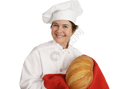 可爱的女厨师笑着举起一锅新鲜面包图片