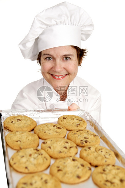 漂亮的女厨师从烤箱里取出一锅新鲜的烤饼干白色孤立无援图片