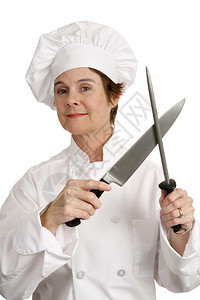 一位有能力的女厨师在磨刀子孤立白色上图片
