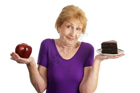 在巧克力层蛋糕和苹果甜点之间选一个适合的老女人孤立在白色上图片
