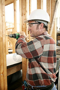 建筑工地的木匠按照安全法规和条例钻探图片