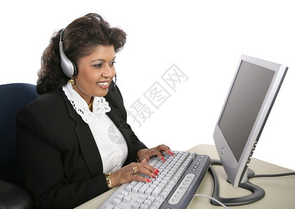 一位有吸引力的印度技术支持专家坐在电脑上戴着耳机图片