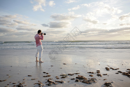 摄影师在海滩拍照图片