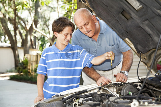 父亲和儿子一起修车正在查油图片