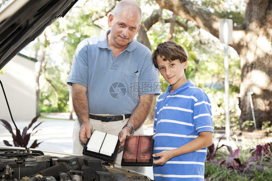 父亲和儿子在家庭车里换空气过滤器图片