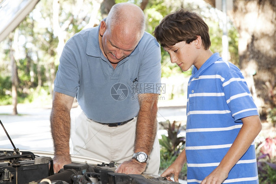 父亲和儿子在汽车引擎上一起工作图片