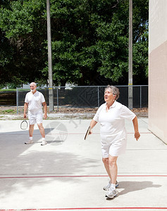 活跃的老年情侣在公园里玩打球图片