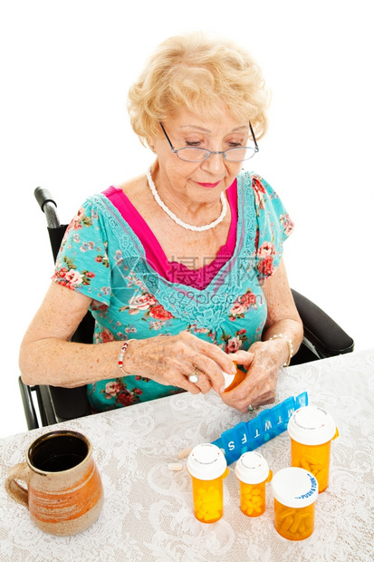 坐在轮椅上的残疾老年妇女算出她一周的药物白种背景图片