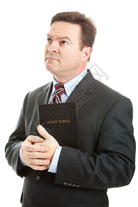 穿着商业西装的信奉宗教基督徒拿着他的圣经看天堂孤立的白种人图片