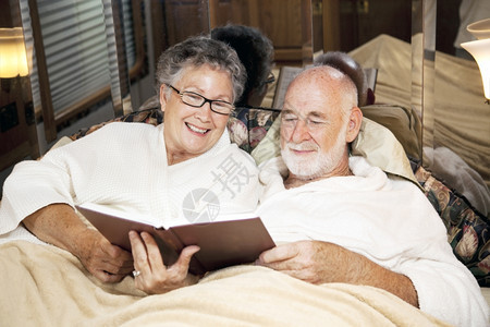 老年夫妇在睡觉时他们的汽车家里一起读书图片