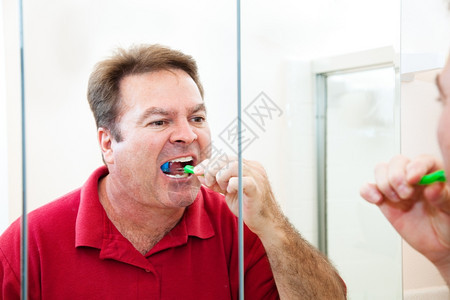 四十多岁的男人在浴室镜子里刷牙图片