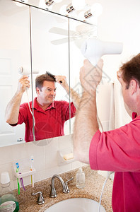洗手间里的人吹的头发这是他早上例行公事的一部分图片