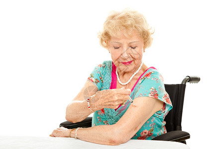 坐在轮椅上的年长女人给自己注射一针白种背景图片